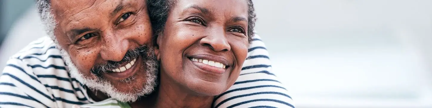 Smiling older couple embracing, representing confident smiles with dental implants at Bridgeport Smiles in Bridgeport, Texas